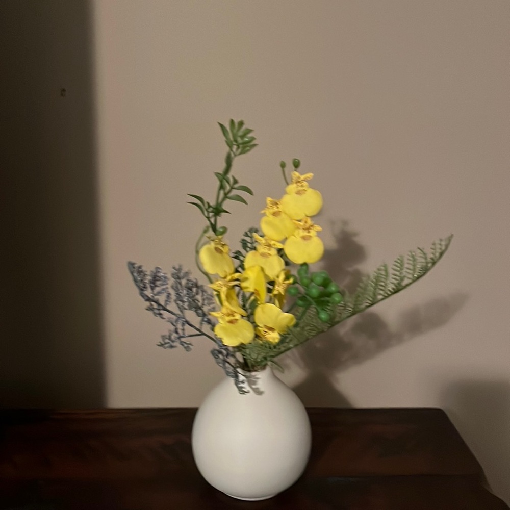 Cream colored ceramic vase with flowers